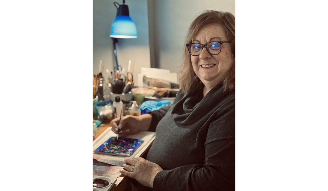 a photo of a woman painting on tile with alcohol ink