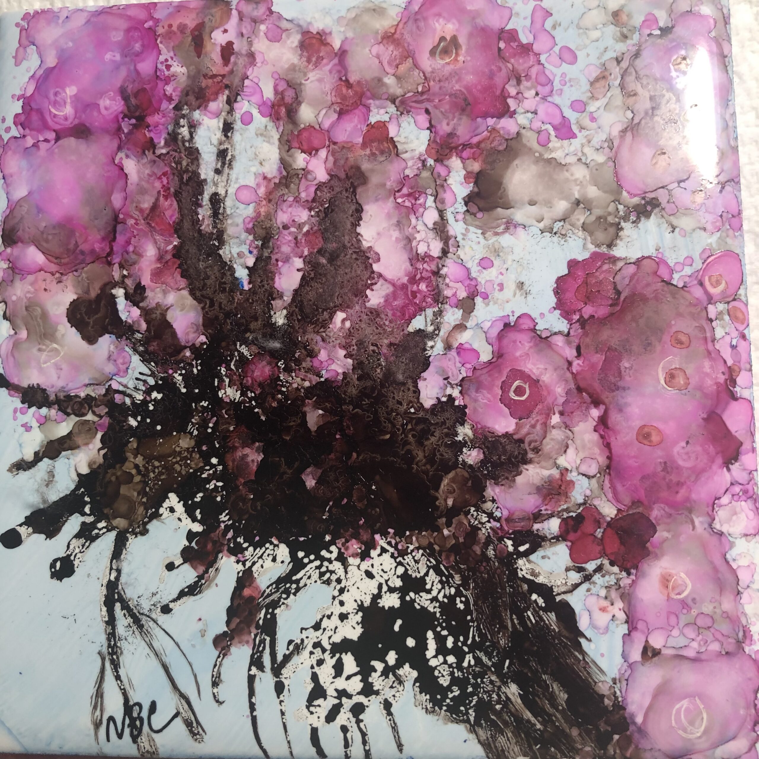 A vibrant purple flower surrounded by dynamic black and white paint splatters, creating a striking visual contrast.