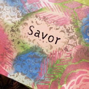 A placemat featuring the word "savor" prominently displayed in an elegant font.