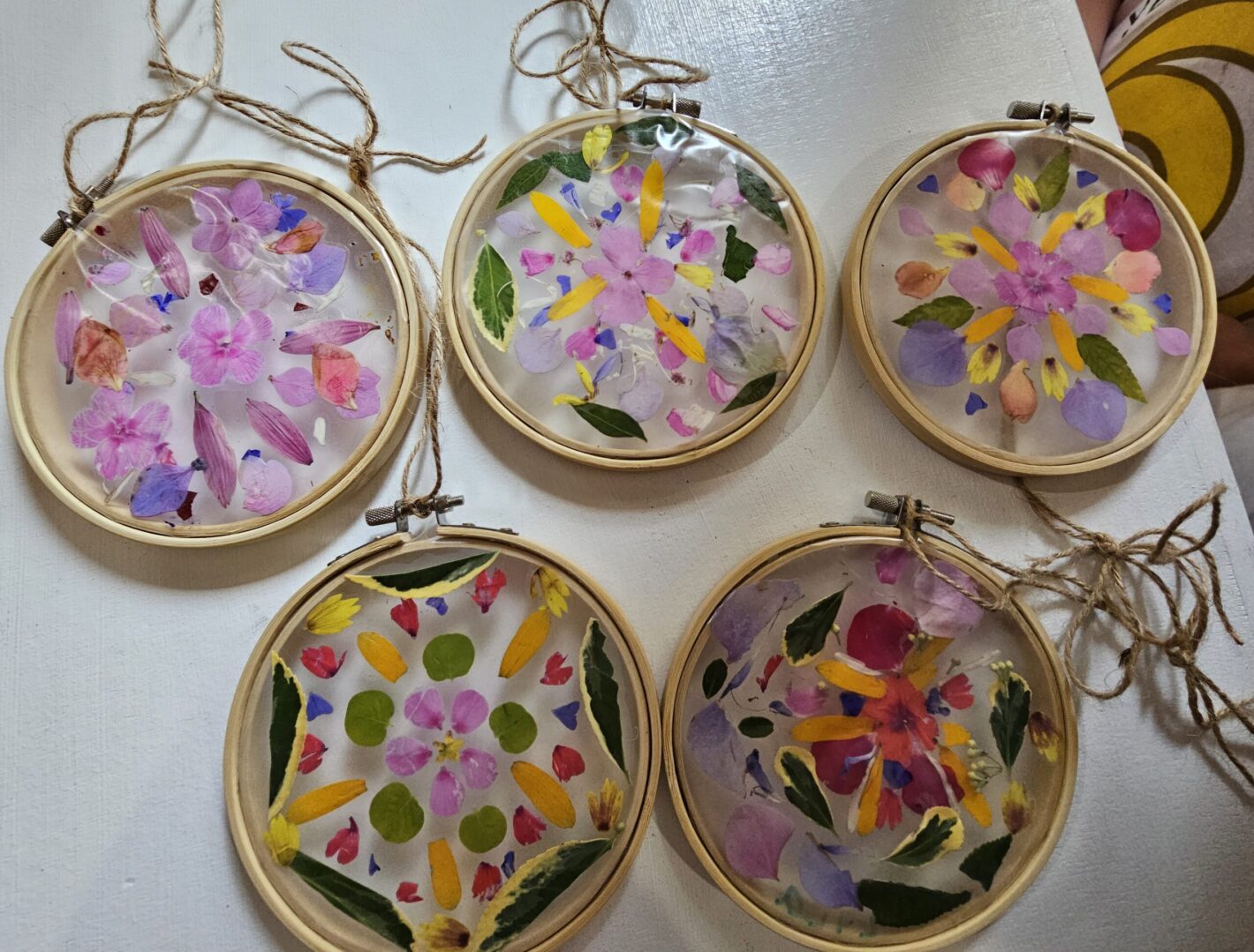 ornaments made with flowers and leaves in an embroidery hoop