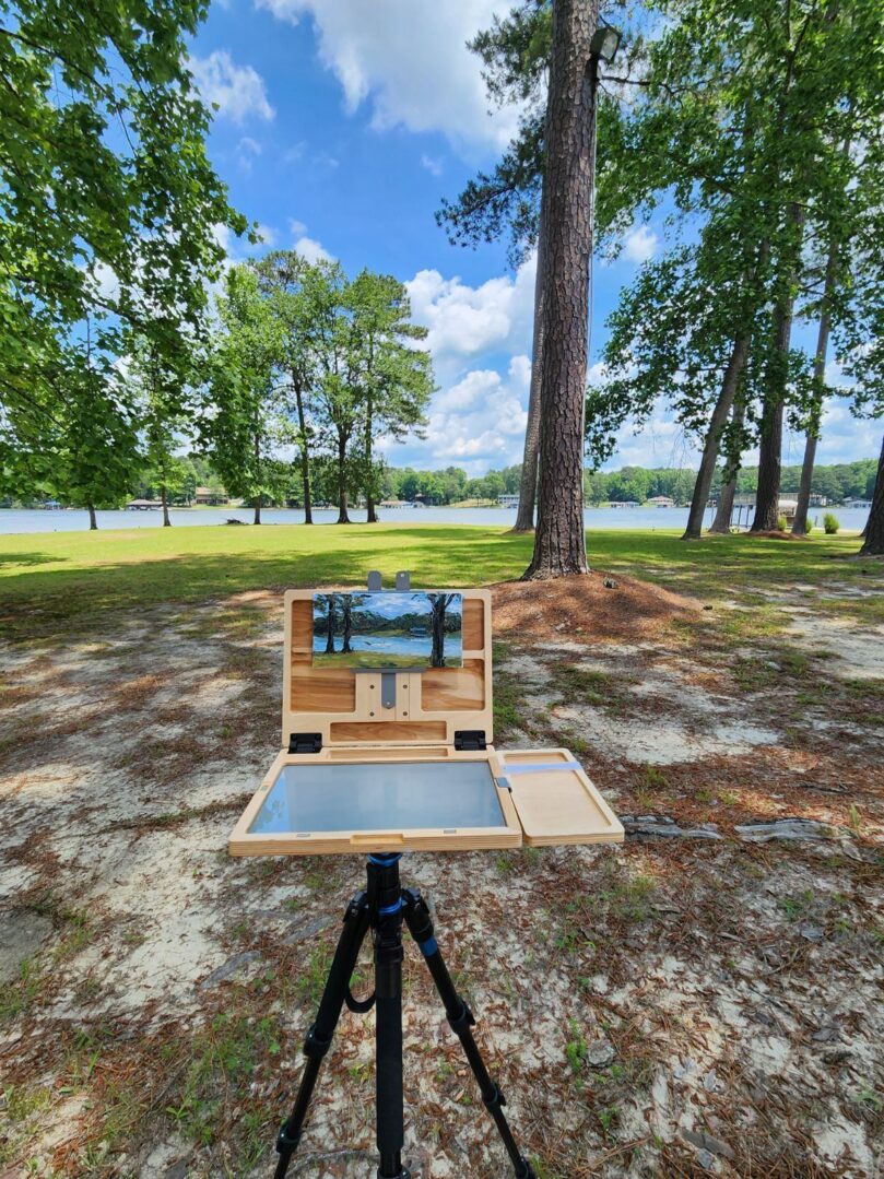 A painting of trees and a lake in the background.