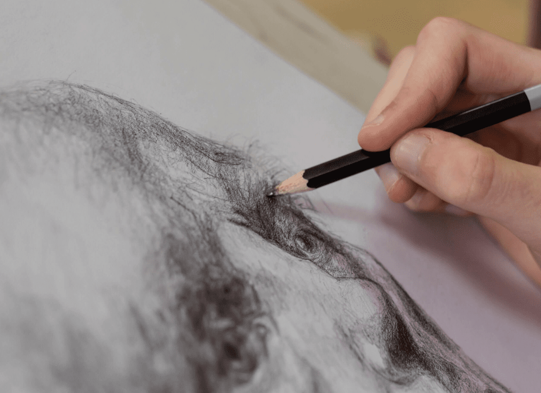 A person drawing an image with a pencil.